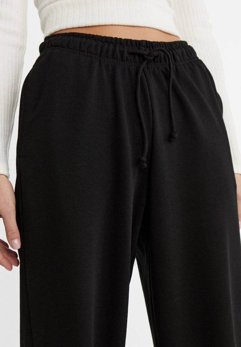 Stradivarius Stradivarius WIDE-LEG JOGGER - Tracksuit bottoms - black Im Verkauf