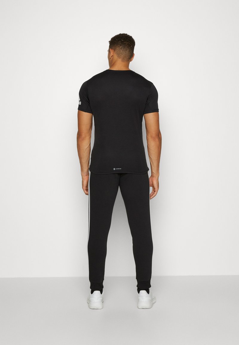 adidas Sportswear adidas Sportswear ESSENTIALS TAPERED CUFF 3 STRIPES PANTS - Tracksuit bottoms - black white Fabrikverkauf