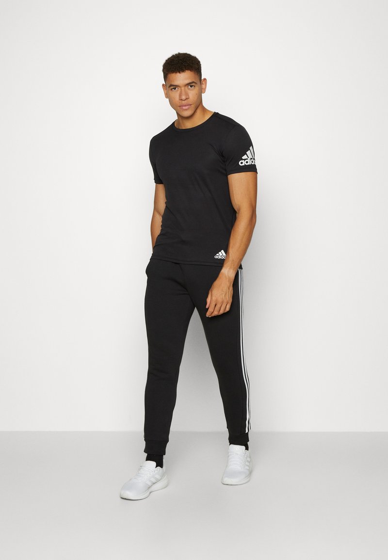 adidas Sportswear adidas Sportswear ESSENTIALS TAPERED CUFF 3 STRIPES PANTS - Tracksuit bottoms - black white Fabrikverkauf